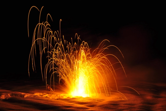 Photo to show a large mass of sodium reacting with water at night